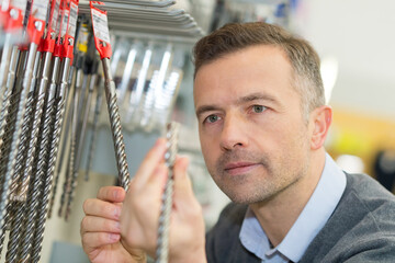 male customer buying working tools in supermarket