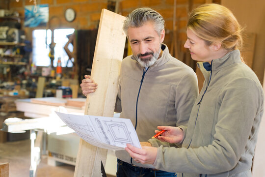 female carpenters measuring wood in workshop