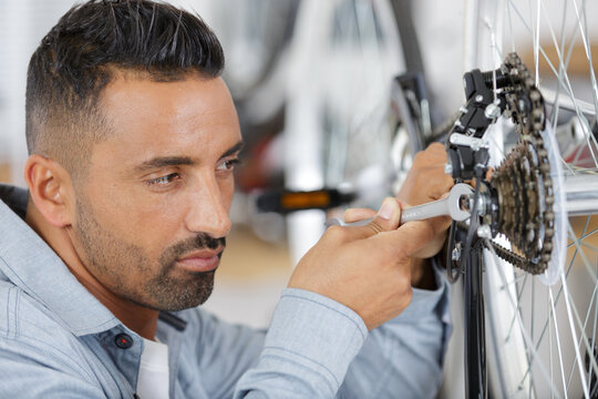 mechanic removing bicycle rear cassette in a workshop