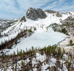 High rock peak in the Idaho wilderness over a frozen lake