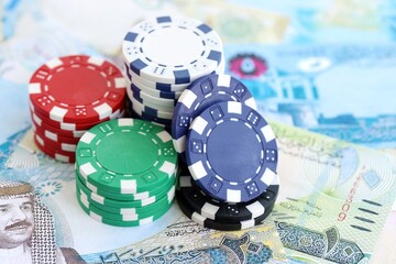 Bahraini dinar currency money bills and bunch of casino chips close up. The concept of gambling and casino games