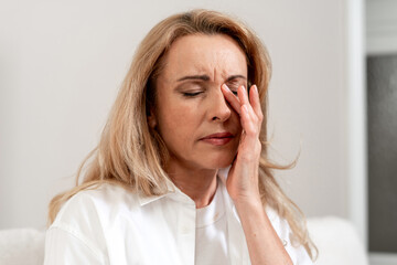 Mature woman experiences migraine and stress while contemplating her problems © brizmaker