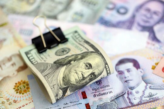 Thai baht currency money bills and bunch of us dollar banknotes close up. The concept of economics and currency exchange