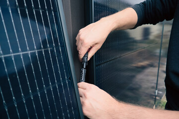 Technician connecting MC4 connectors between solar panels during installation
