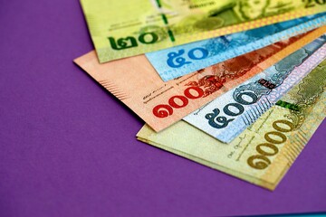 Thai baht money bills in big amount on purple close up. Finance and banking concept