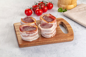 Raw pork tenferloin with bacon
