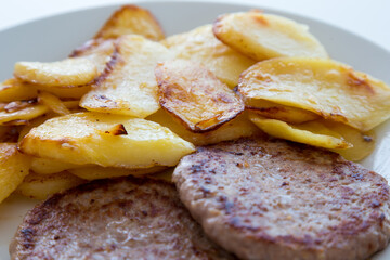 Hamburger e patate arrosto su piatto bianco
