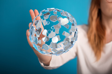 A woman's hand holding a 3D sphere made of speech bubbles, conveying communication, connection, and...