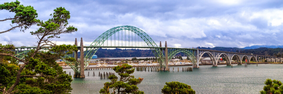 Yaquina Bay Bridge Panorama With Boats In The Harbor and a Moody Blue Sky