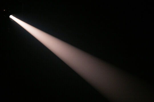 Apenas um feixe de luz de palco, em ambiente totalmente escuro.