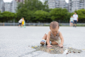 Fototapeta premium Cute baby splashing water on stone ground