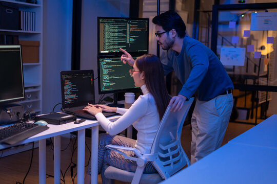 Asian software engineer or programmer team working late in development office,problem solving or algorithm of ai assistant helping for work.software developer,digital technology security concept