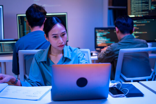 Asian software engineer or programmer team working late in development office,problem solving or algorithm of ai assistant helping for work.software developer,digital technology security concept