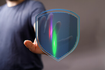 Image depicting cyber security, data protection, and digital shield concept. Person holding a transparent shield with data streams wi