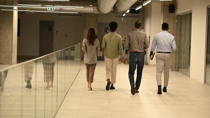 Diverse business team walking through a modern office corridor