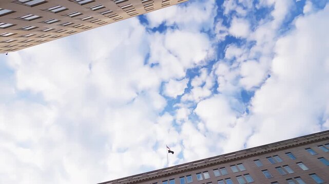 Veterans Affairs HQ building in Washington D.C. is revealed with a tilting down video shot of its grand facade, US flag, and main entrance against a cloudy sky.