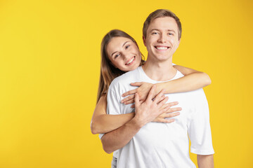 Lovely couple hugging on yellow background, space for text. Romantic date