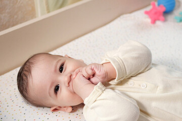 Mother doing massage on her healthy infant baby. Caring Woman Making Gymnastics To little Baby