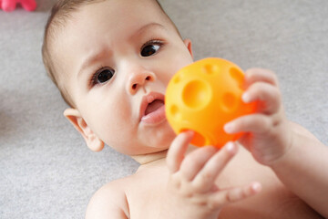 Cute adorable newborn baby playing with colorful rattle toy. baby with teether. six months old...