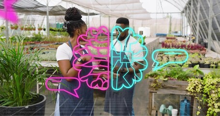 Inspecting nursery staff in aprons discussing plants in greenhouse holding phone neon AI overlay