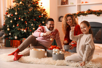 Happy family with ornaments near Christmas tree at home, selective focus
