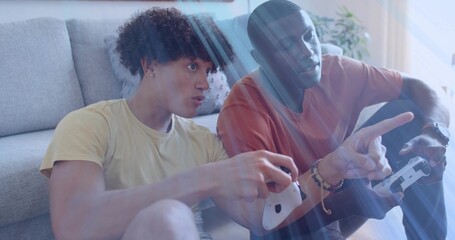 Playing two friends in yellow and rust tees with wireless controllers at home, sunlight streaks