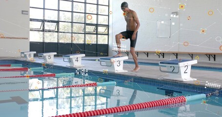 Preparing male swimmer standing on block #3 on deck, wearing cap and jammers, copy space