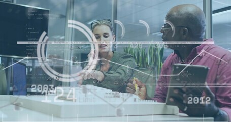 Showing woman green-top and senior man maroon-shirt checking tablet at glass room with data