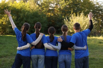 Group of volunteers together in park, back view