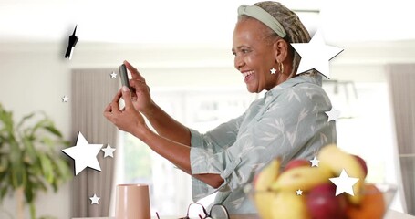 Senior woman holding smartphone, tapping screen, activating stars, reacting to message for tech - Powered by Adobe