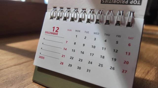 Slow motion footage of the calendar page changing from November to December, the last month of 2025. 4k horizontal.