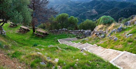 Mountain picnic area with wooden tables and scenic valley view in Crete