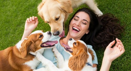 A joyful woman laughing on the grass while being licked by three affectionate dogs. A pet owner enjoying a happy moment outdoors. The concept of love and friendship between humans and animals