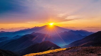 A view of the sun setting over the mountains from the top of a mountain