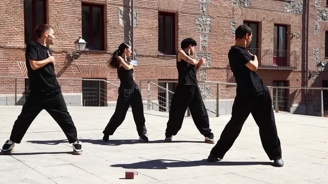 Urban dancers performing synchronized choreography on a sunny day