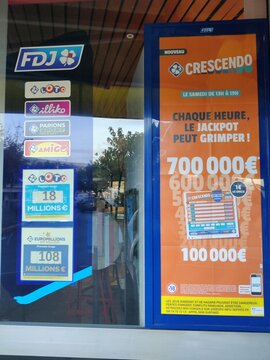 Royan, France - November 09, 2025: FDJ lottery storefront display featuring Crescendo jackpot promotion with colorful signage and enticing prize amounts visible in the window