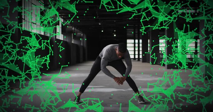 Athlete bent, shifting wide-leg stretch in warehouse, green particles framing body for fitness