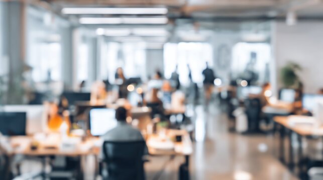 Busy open plan office interior with blurred working people and desks.