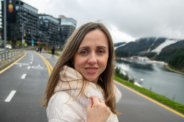 Portrait of a woman against the backdrop of a winter mountain lake.