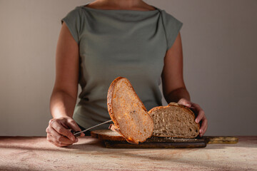 Mid shot of person Lifting Sourdough Slice with Bread Knife Fork Tip