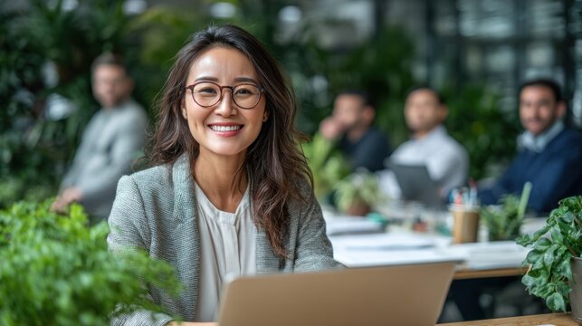 Smiling woman with glasses works on laptop surrounded by greenery. - Powered by Adobe
