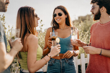 Friends enjoy refreshing drinks under the sun during a cheerful gathering at the beach during a...