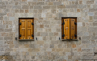 Greek house wall with two wooden windows