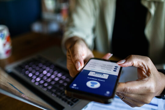 Focused adult using mobile banking app at home office