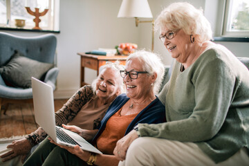Senior women laughing over laptop at home