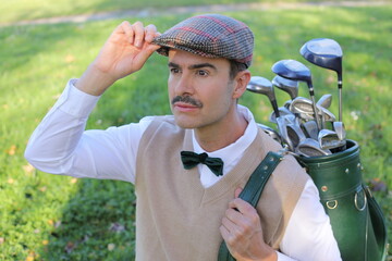 Golf player adjusting his hat during a sunny day 