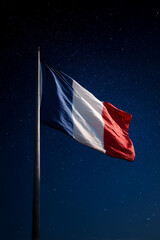 French flag waves proudly against a blue sky during Bastille Day highlighting patriotism and celebration