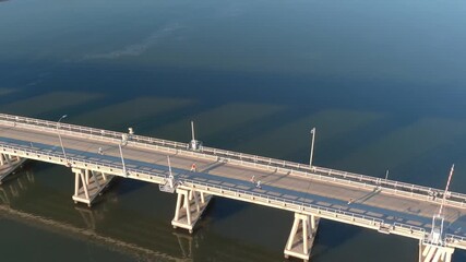 Aerial shot of people running a race across a bridge over water.