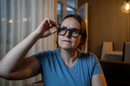 Mature woman using AR glasses with AI assistant, exploring futuristic technology and innovation.
