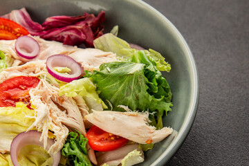 Salad chicken meat and vegetables tomato, green leaf lettuce, onion natural product tasty snack fresh delicious gourmet food background on the table rustic top view copy space keto and paleo diet